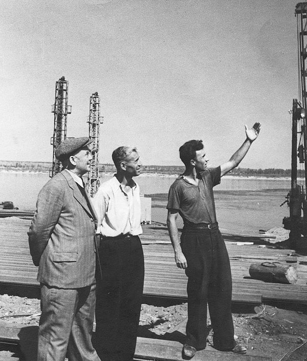El Ingeniero Jefe de la Construcción coronel Sháposhnikov, el jefe del sector capitán Cherviakov y el autor analizan la situación en la construcción de la ataguía